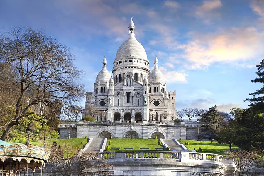 Which famous landmark is located at the top of Montmartre Hill?